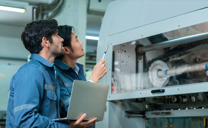 CMMS enables predictive maintenance engineer professional having discussion standing consult machine factory