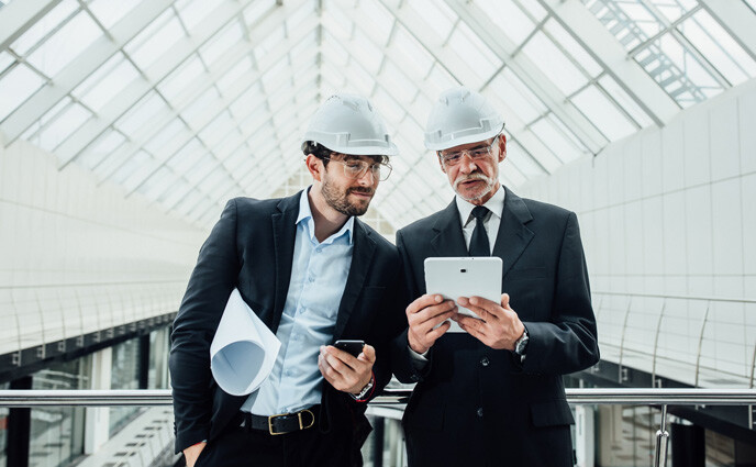 Facility maintenance plan two entrepreneur with heltmet in new building