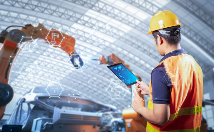US presidency impact on maintenance management technician holding a tablet and robotic arm