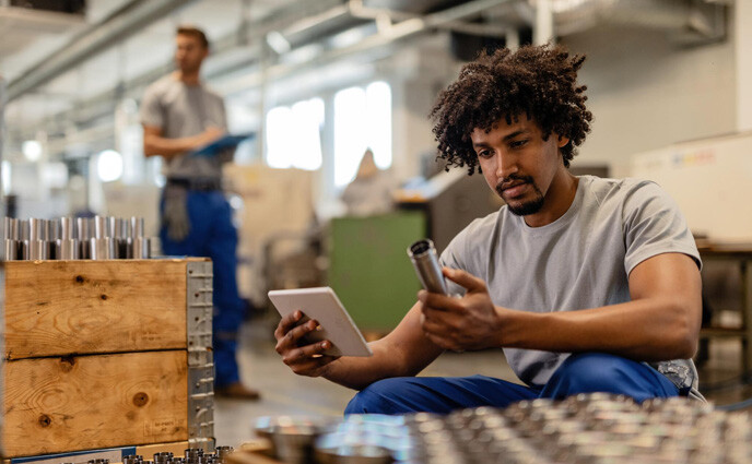 cmms for discrete manufacturing or process manufacturing factory worker checking spare parts