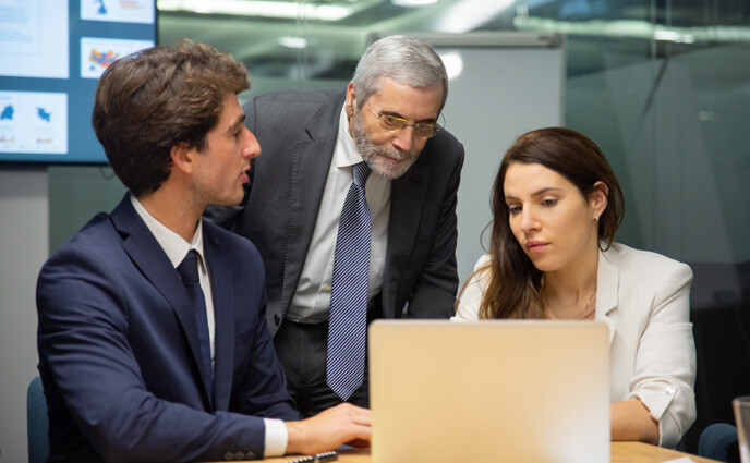 cmms buying process business team looking laptop