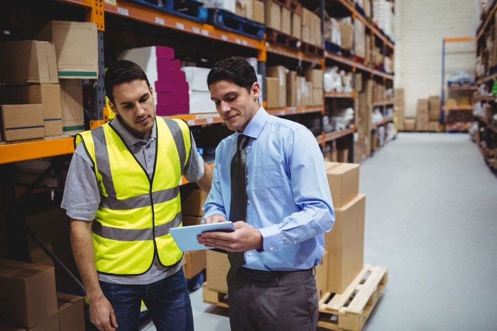 cmms inventory management KPIs manager showing tablet worker warehouse