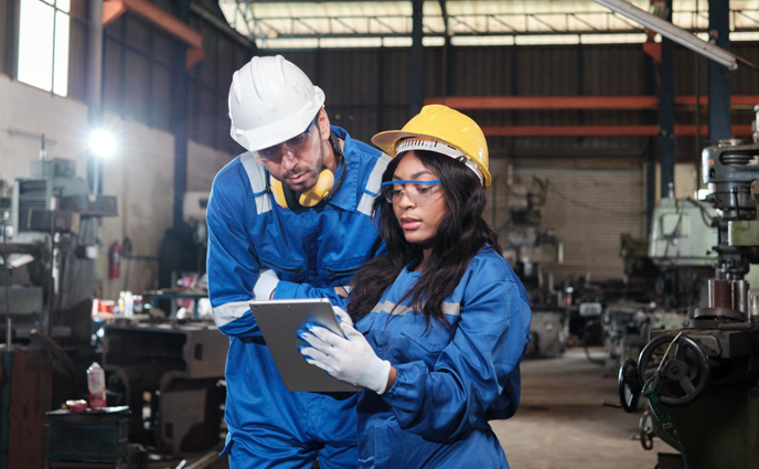 cmms software adoption strategies two industrial workers metalwork with tablet
