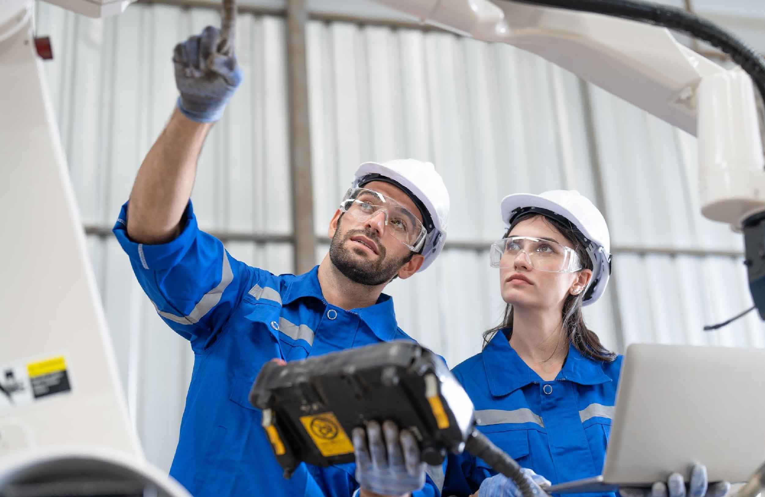 cmms software features male female engineer using remote controller control robot arm