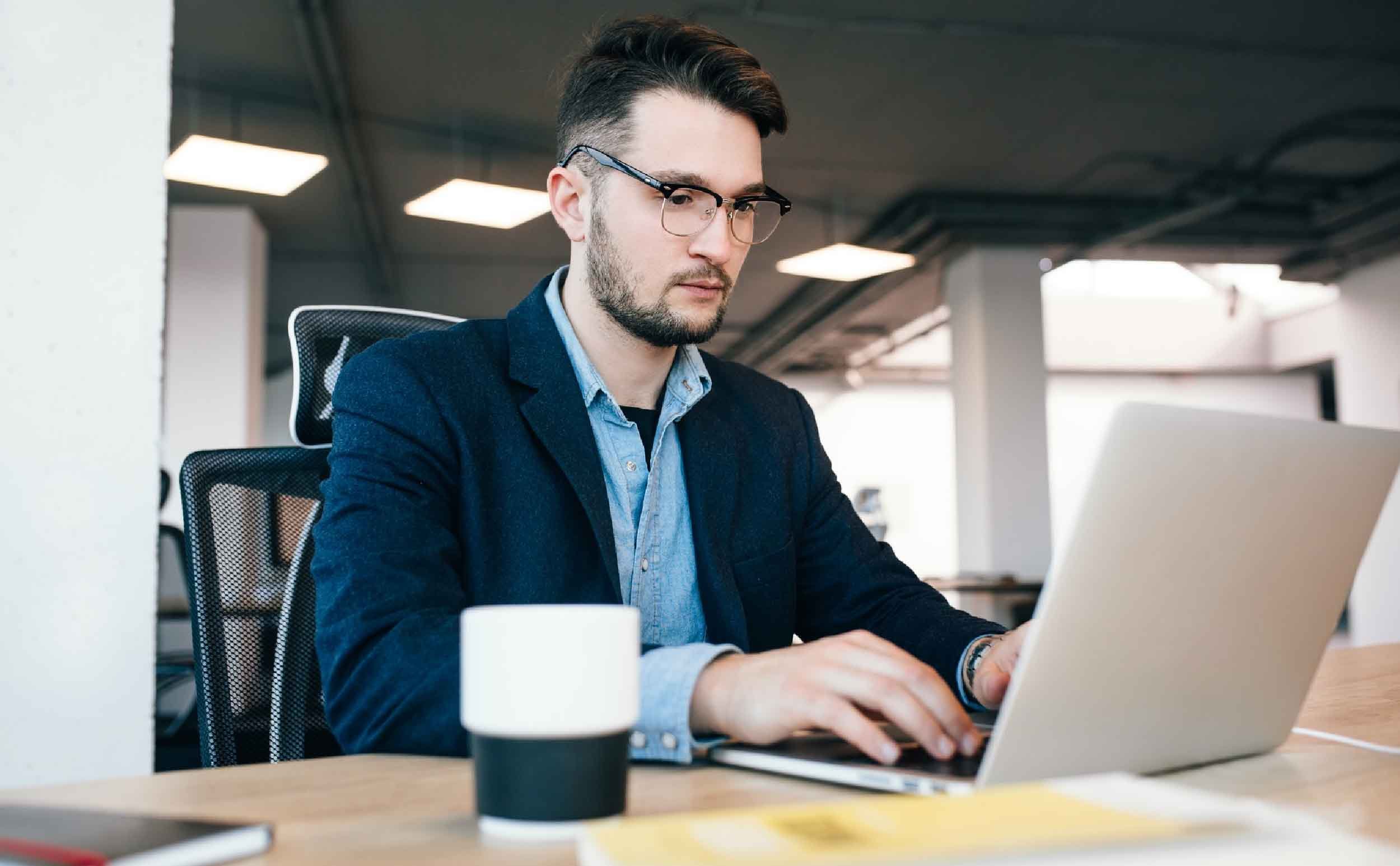 cmms software for government young dark haired man is working table office