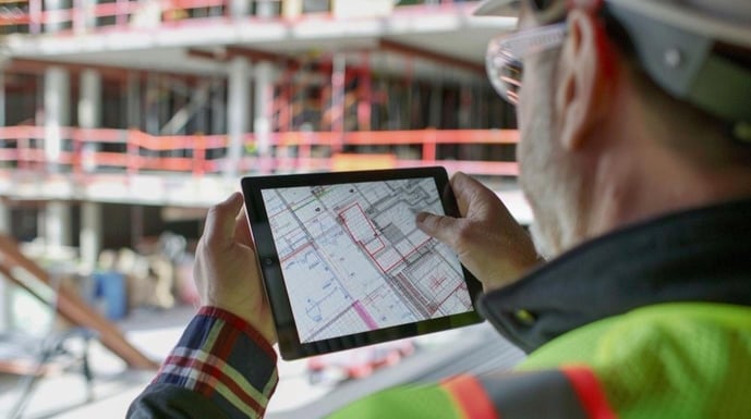 facility condition assessment man is holding tablet with map in it