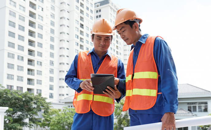 facility maintenance plan civil engineers using tablet near building