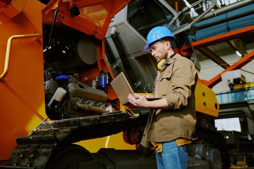 heavy equipment preventive maintenance checklist caucasian engineer using laptop work