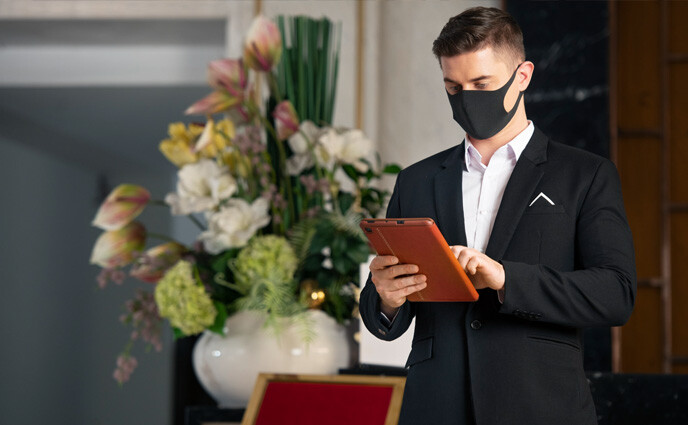 hotel preventive maintenance checklist hotel receptionist checking tablet