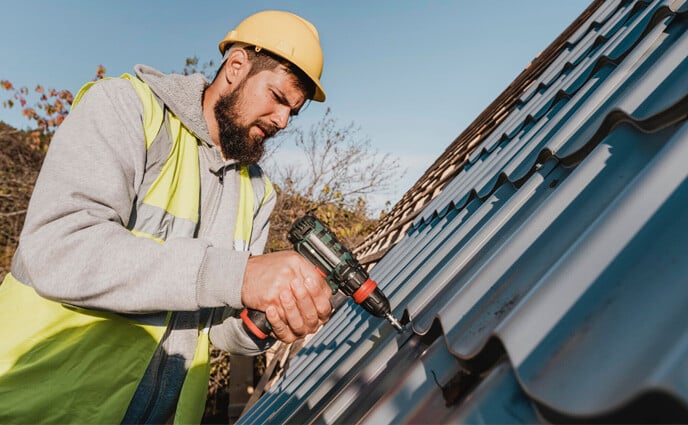 building maintenance checklist man working roof with drill