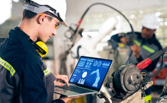 maas facility management techician with cmms software on laptop