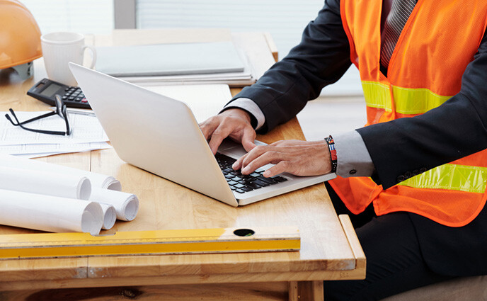 maintenance contracts zoomed in factory worker working on laptop