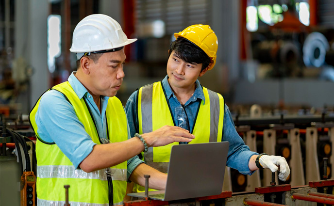 maintenance planning group engineers hardhats using digital tablet