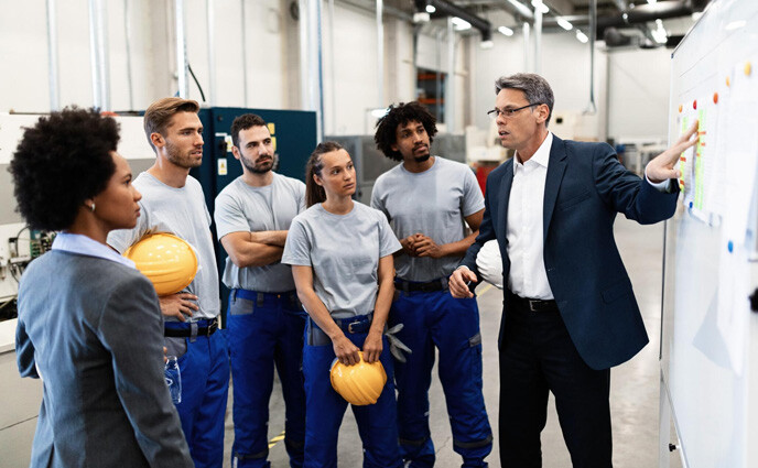 maintenance talent shortage manager giving presentation group factory workers