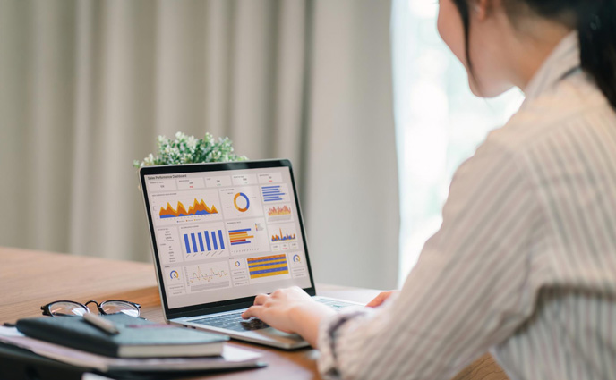 maintenance tracking best practices woman analyzing data charts graphs dashboard laptop