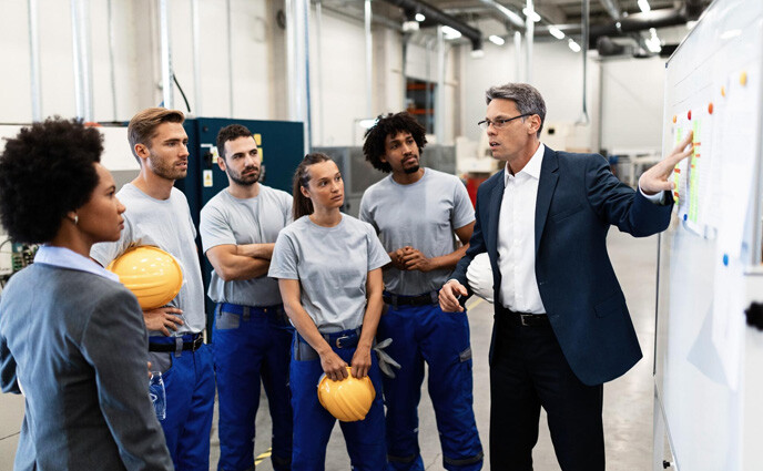 manufacturing maintenance manager giving presentation group factory workers