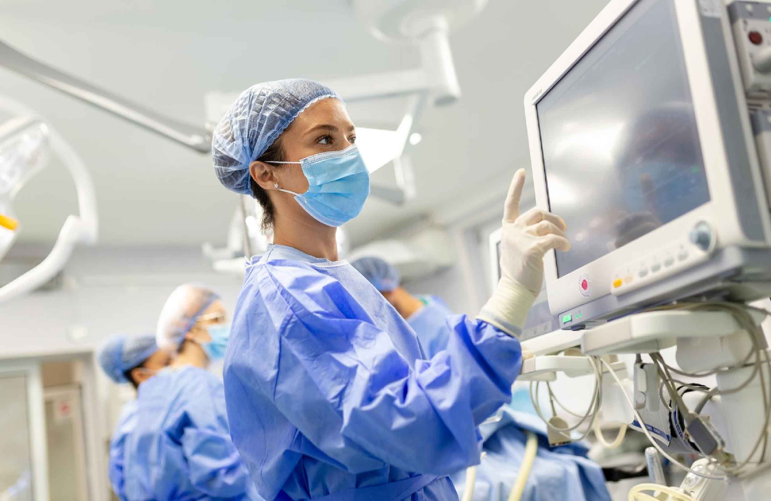 medical equipment maintenance management software female doctor scrubs protective facmask preparing anesthesia machine