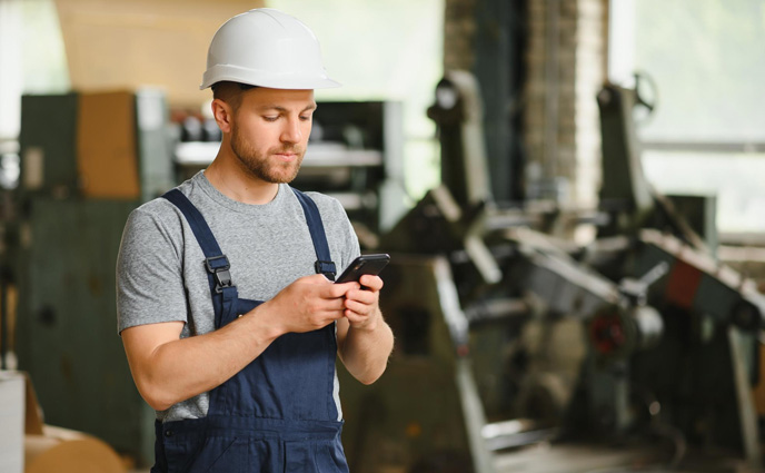 mobile cmms software engineer foreman standing checking phone