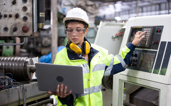 planned maintenance percentage engineer using laptop while operating machine factory