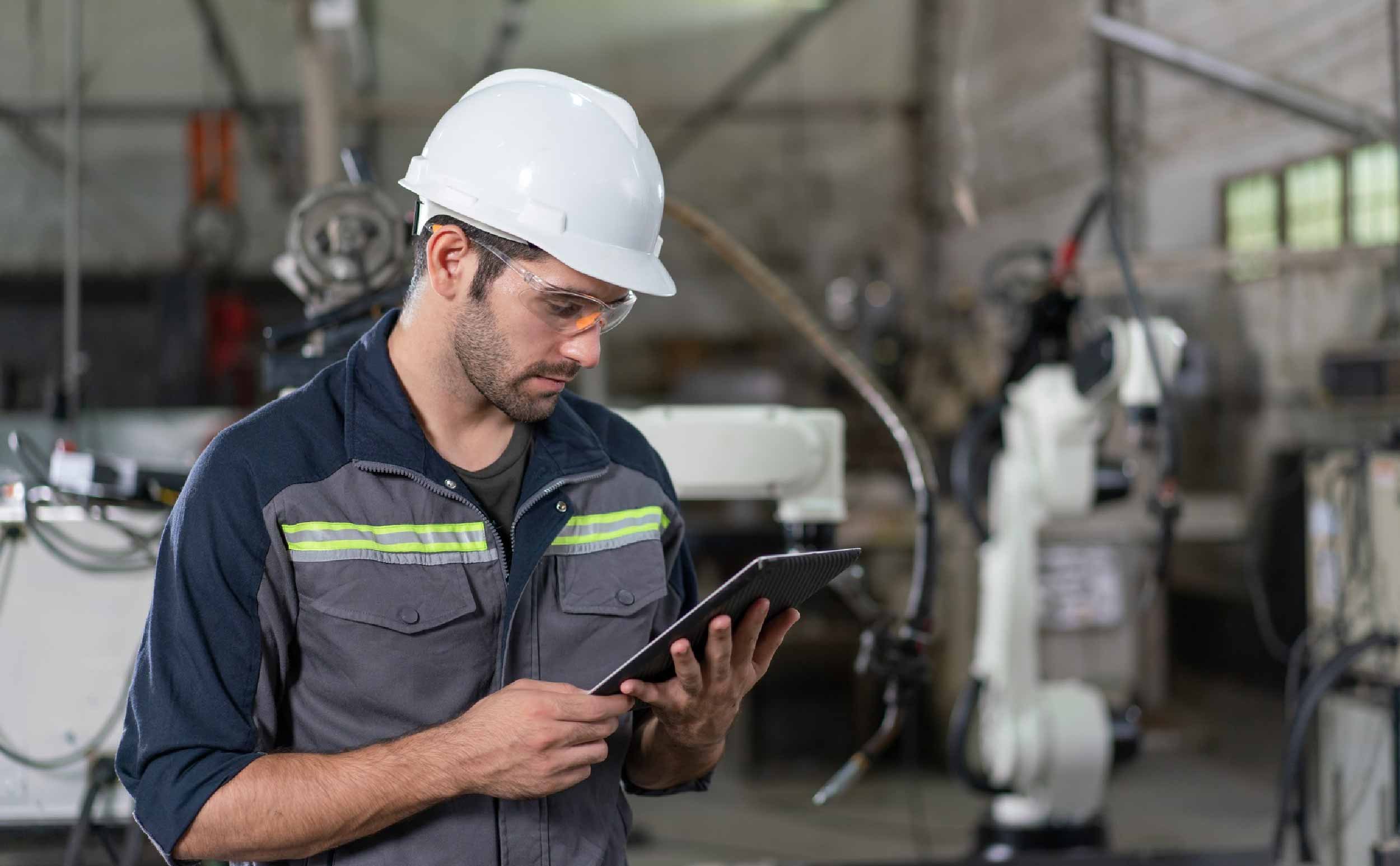 preventive maintenance compliance importance engineer using tablet control robot arm industrial factory