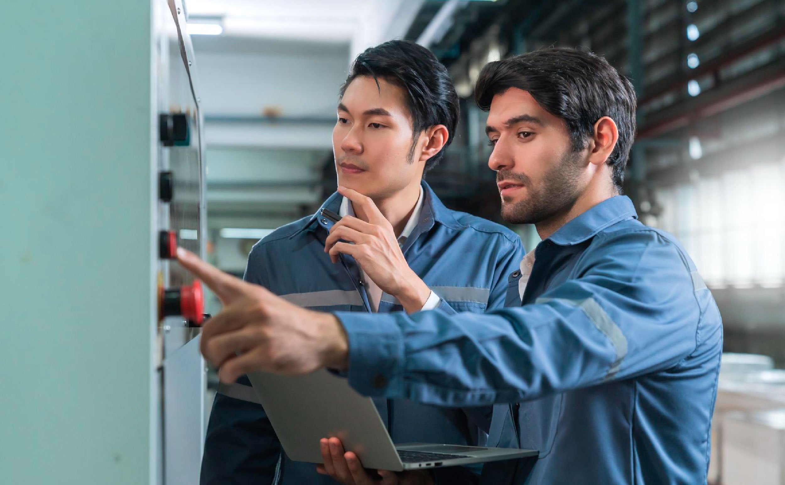 preventive maintenance manufacturing two male technicians discussing in factory
