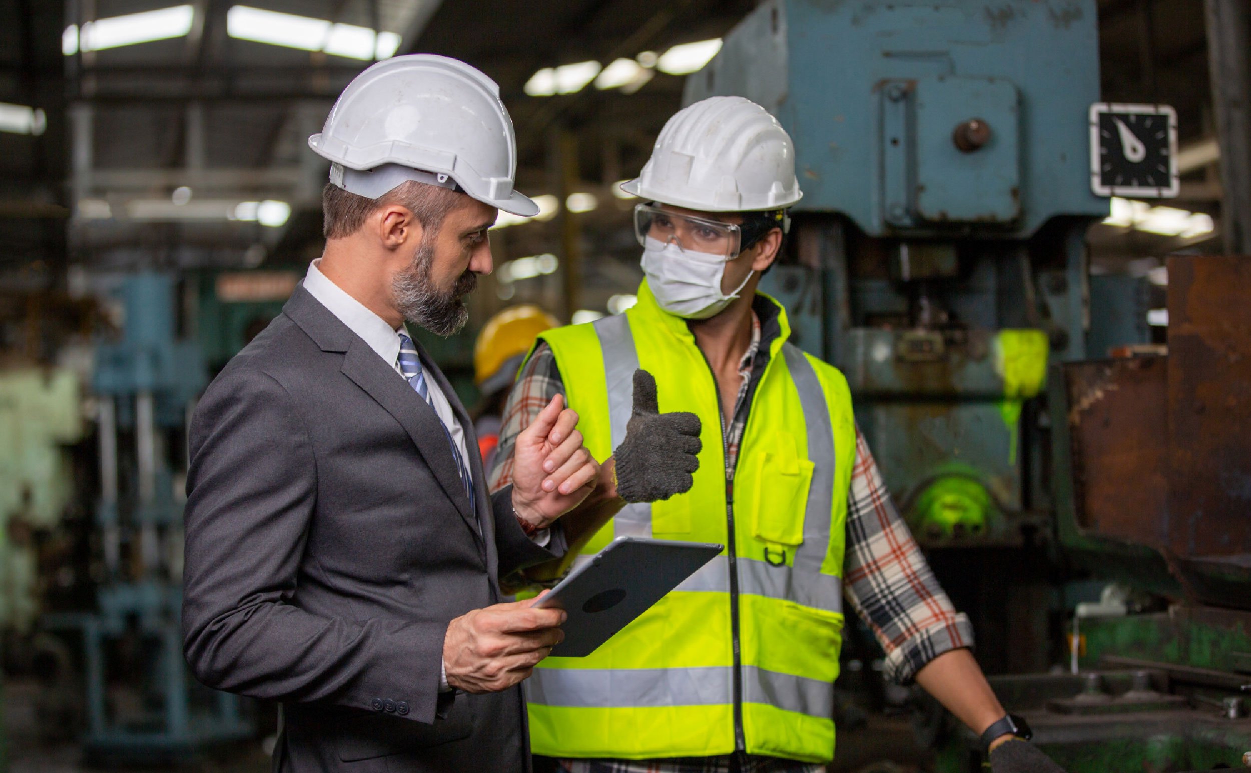 preventive maintenance manufacturing two male technicians working discussing holding tablet factory