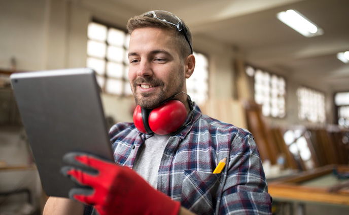 redlist cmms alternatives middle aged professional worker carpenter with ear protectors using tablet