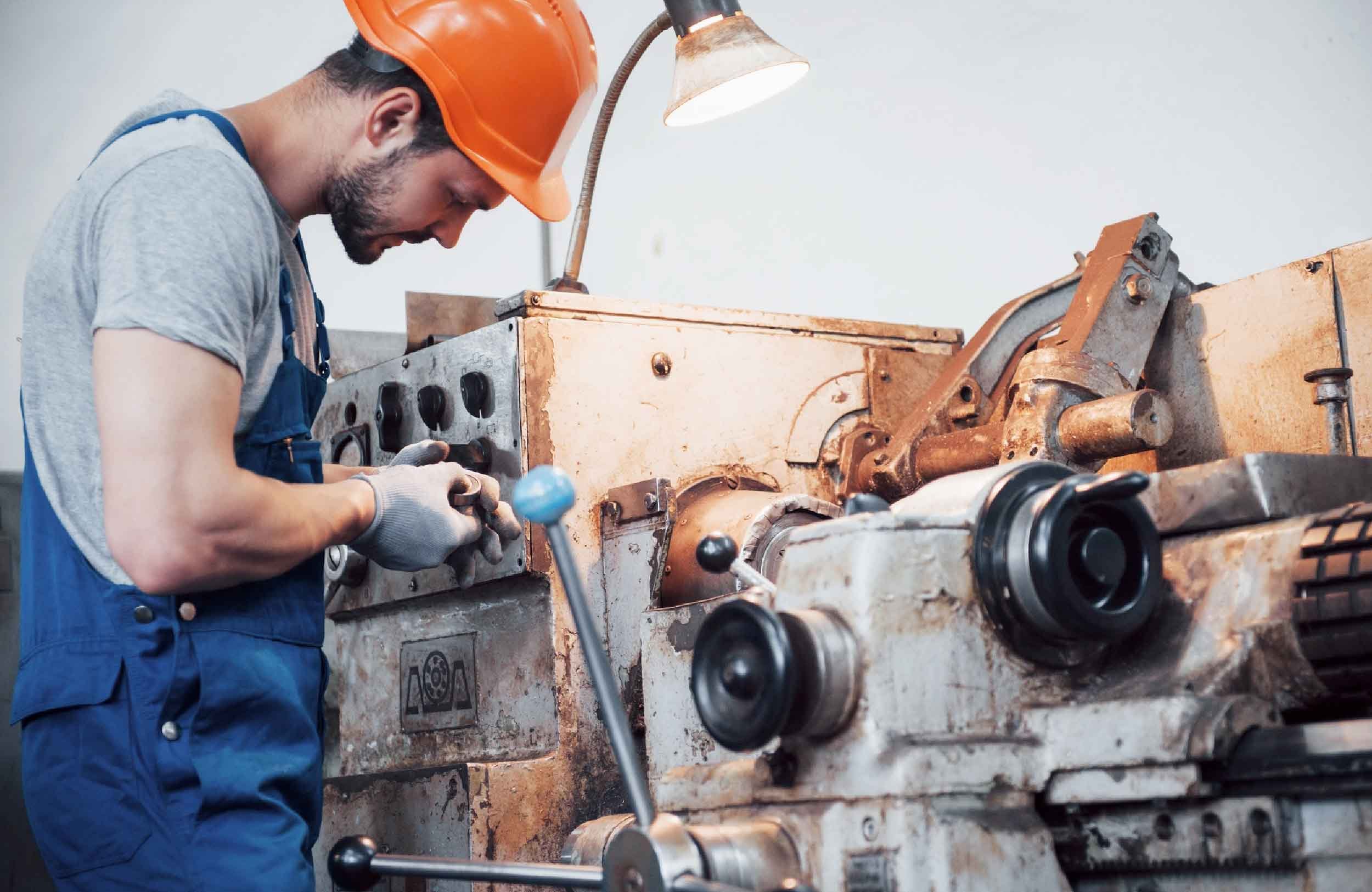 replacement asset value young worker hard hat large metalworking plant