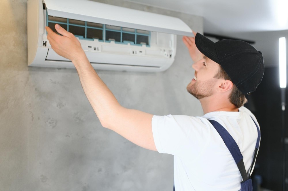 school facility inspections happy male technician repairing air conditioner