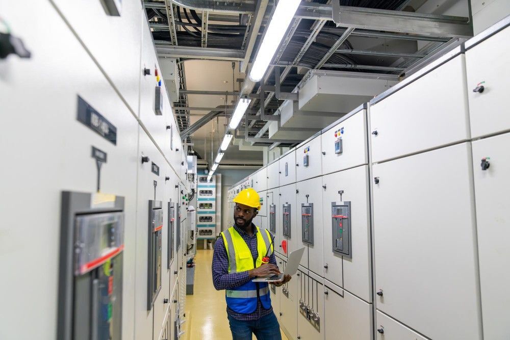 school operations management african man engineer working laptop electric control panel