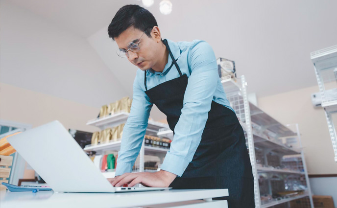 small business work order software male business owner working on laptop