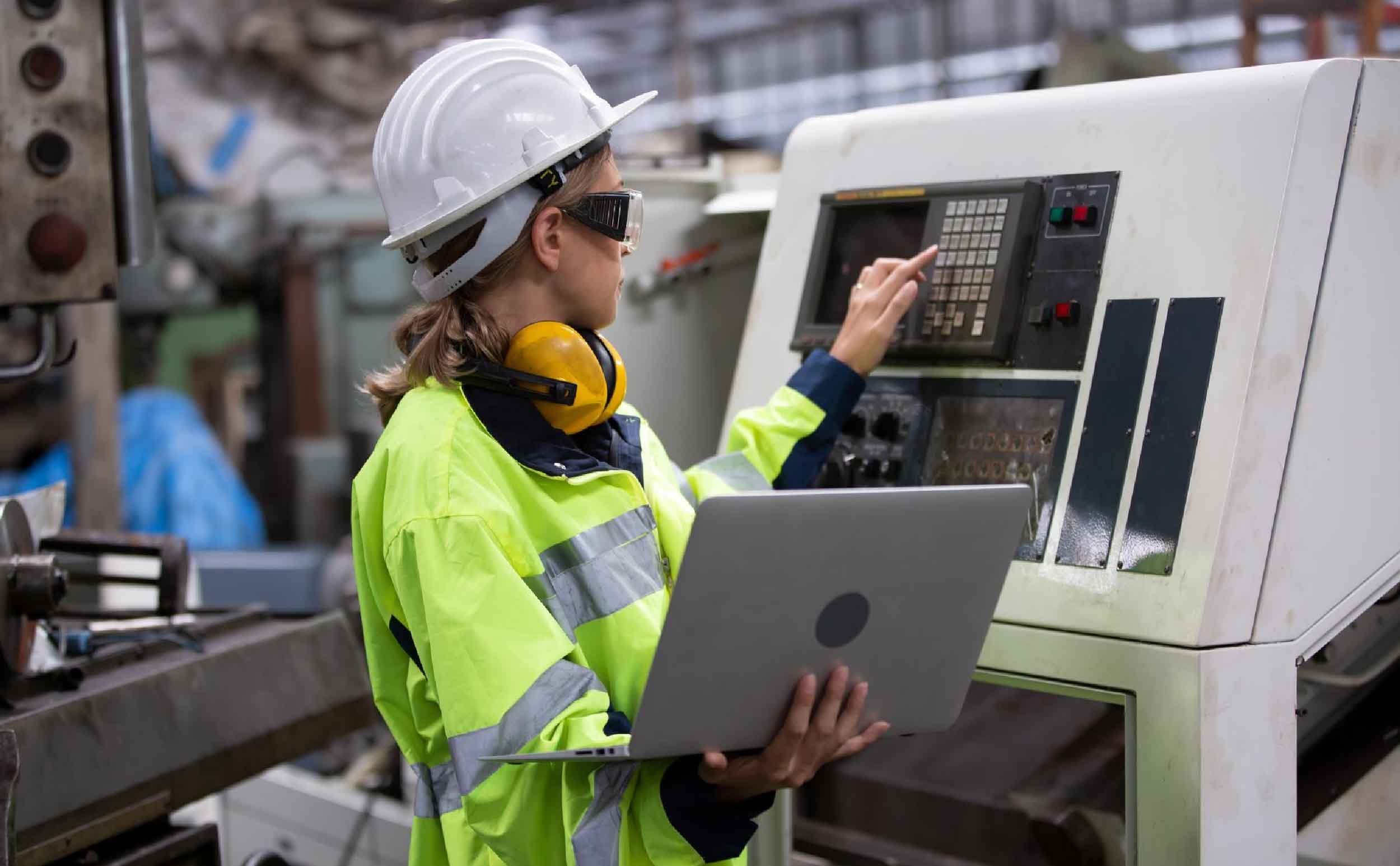 work order process engineer using laptop while operating machine factory